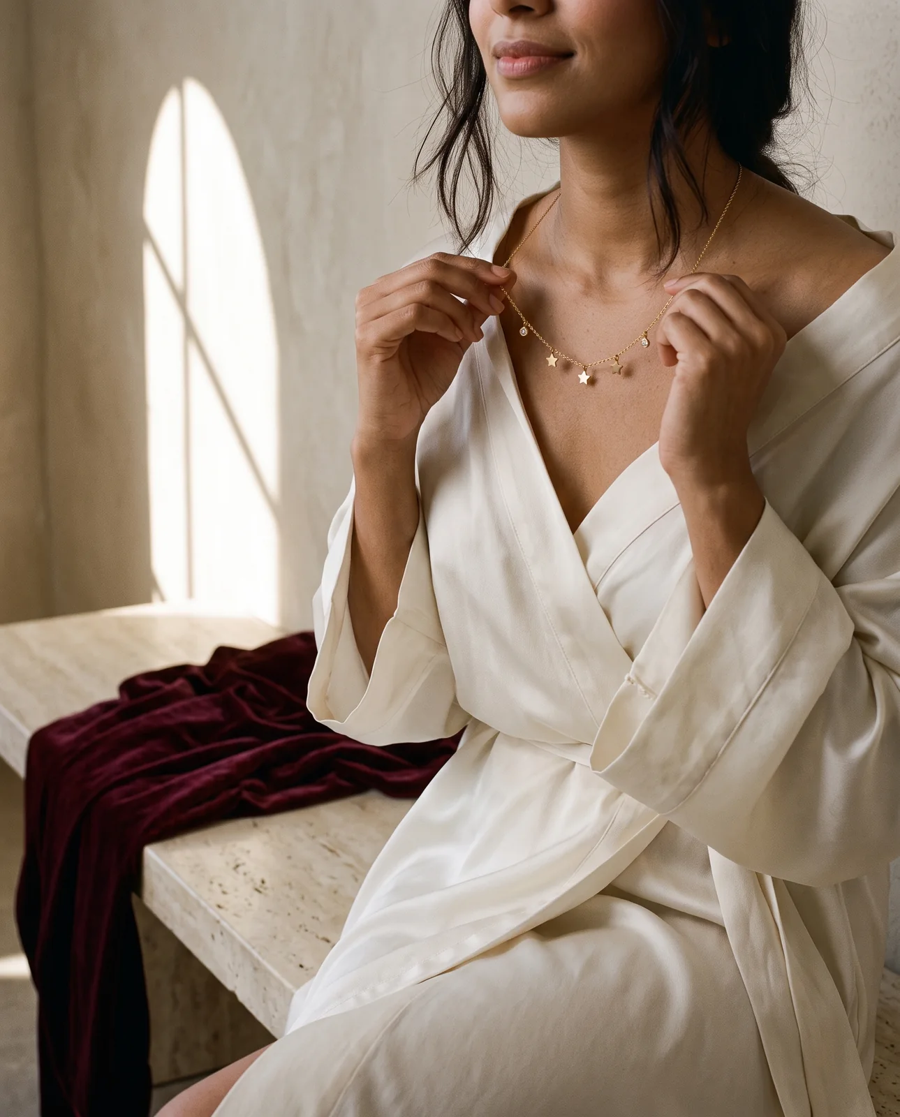A woman trying the Stella Rêve necklace at home